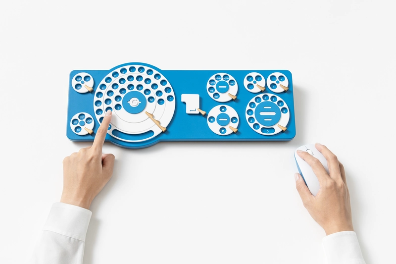 The 2025 Gboard Dial Version, a blue keyboard of rotary dials being used with one finger alongside a mouse